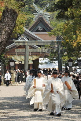 Priests in white robes processing through the shrine grounds