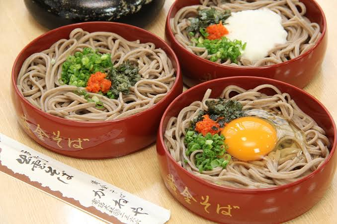 Three tiers of warikko soba topped with condiments and egg