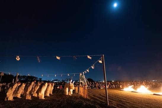 Priests welcoming the gods by bonfire light under the moon during the god-welcoming rite