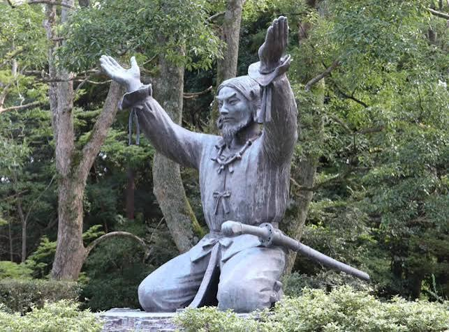 A statue of Okuninushi raising both hands to receive a glowing orb