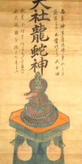 A hanging scroll titled 'Taisha Ryujashin' depicting a coiled dragon-serpent deity